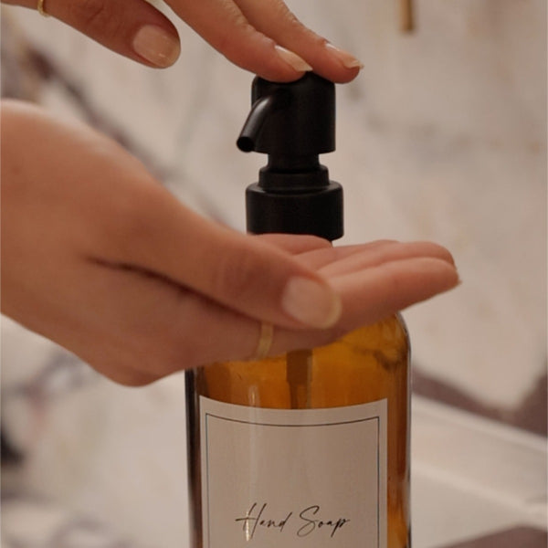NIKITA amber glass dispenser bottle set with stainless steel pumps for your kitchen or bathroom. Durable soap dispensers with waterproof labels for hand soap, dish soap, hand lotion or hand sanitiser.
