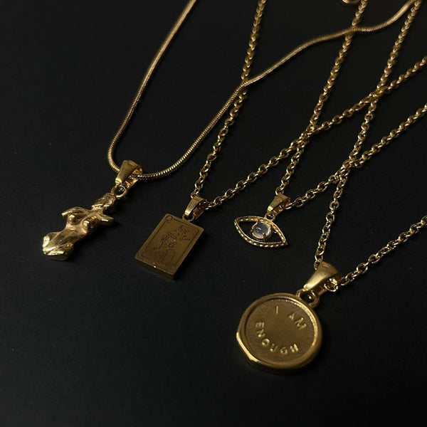 NIKITA 'I am Enough' engraved pendant necklace with a unique wax stamp inspired design and 18k plated gold finish. A water-resistant pendant and adjustable chain made with a hypoallergenic stainless steel base. Christmas everyday jewellery gift for her.