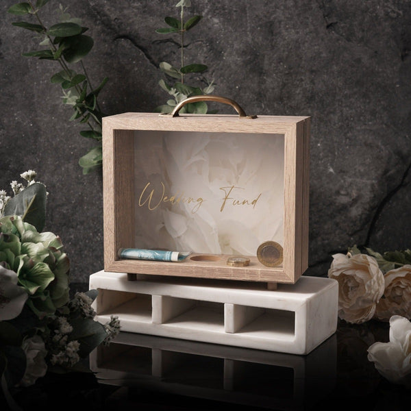 NIKITA wedding photo fund money box. An adult piggy bank to help couples with wedding savings. An adult piggy bank with italic text and a white floral background. Engagement gift for couples.