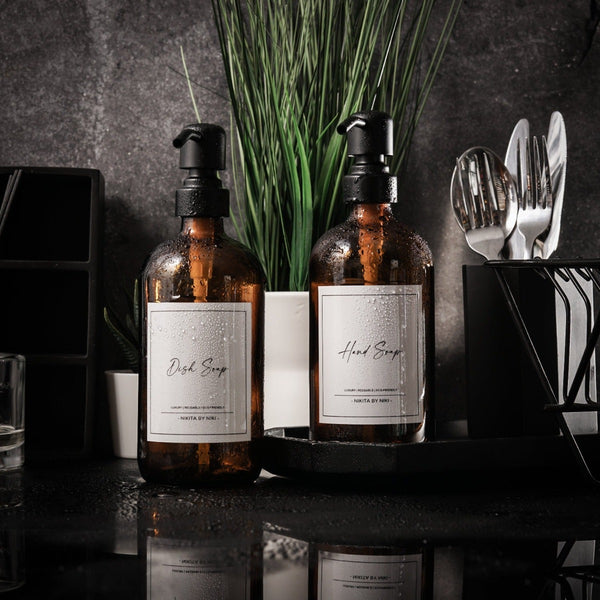 NIKITA amber glass dispenser bottle set with stainless steel pumps for your kitchen or bathroom. Durable soap dispensers with waterproof labels for hand soap, dish soap, hand lotion or hand sanitiser.