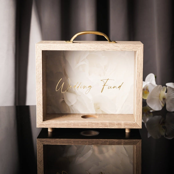 NIKITA wedding photo fund money box. An adult piggy bank to help couples with wedding savings. An adult piggy bank with italic text and a white floral background. Engagement gift for couples.