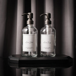 NIKITA clear glass dispenser bottle set with stainless steel pumps for your kitchen or bathroom. Durable soap dispensers with waterproof labels for hand soap, dish soap, hand lotion or hand sanitiser.