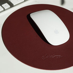 Luxury mouse mat in burgundy made from vegan PU leather featuring a suede non slip base and embossed logo. Perfect for your office or workspace and also available in nude/cream.