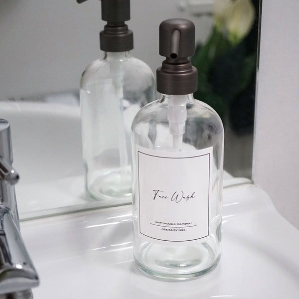 NIKITA clear glass dispenser bottle set with stainless steel pumps for your bathroom. Durable soap dispensers with waterproof labels for shampoo, conditioner and body wash. Ideal new home gift for her or gift for couple.